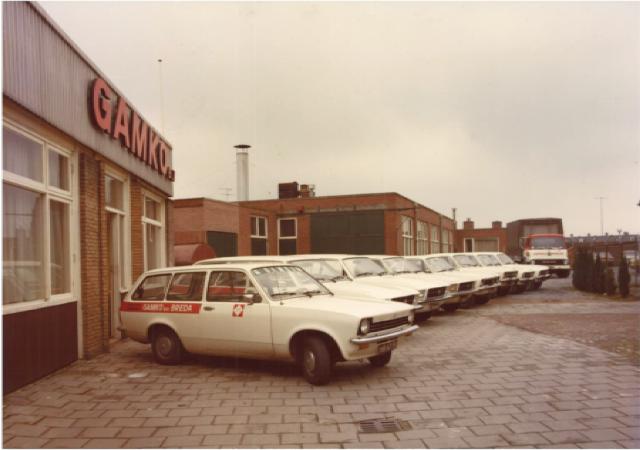 des voitures anciennes sont garées devant le bâtiment Gamko