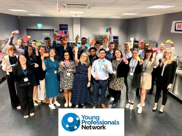 YPN members smiling and holding post it notes
