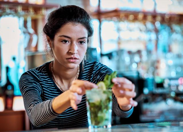 bartender puts finishing touches to a drink