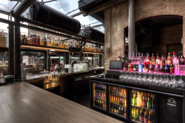Le bar est superbement aménagé avec un meuble Gamko à l'arrière du bar et des bouteilles magnifiquement éclairées à l'intérieur et sur le dessus.
