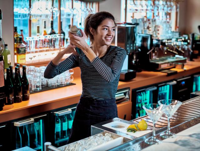 a bartender shakes a cocktail