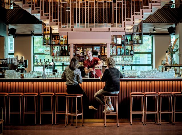 two customers are served at a bar